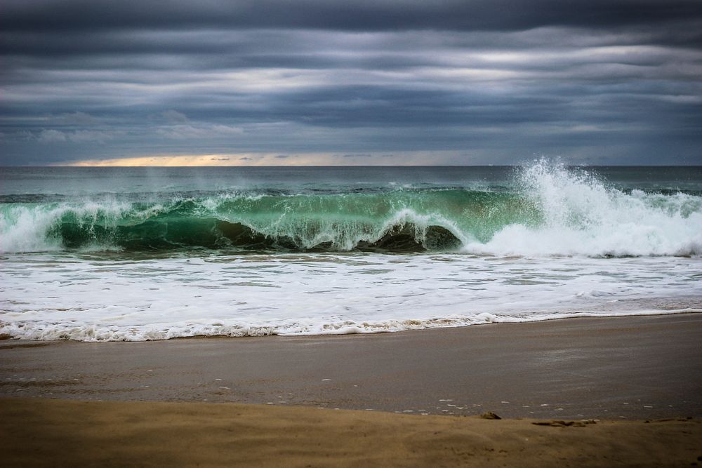 Sea waves crashing onto sand. Free public domain CC0 photo.