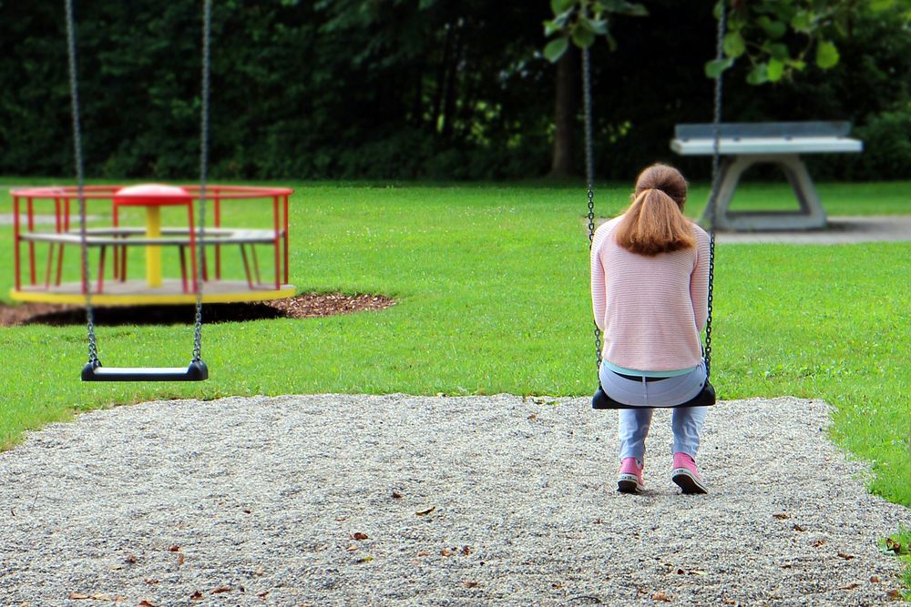 Sad girl on a swing. Free public domain CC0 photo.