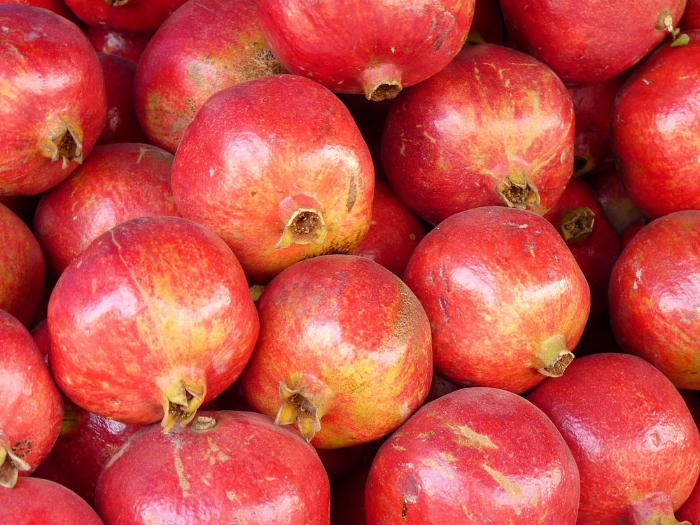 Closeup on pile of pomegranate fruit. Free public domain CC0 photo.