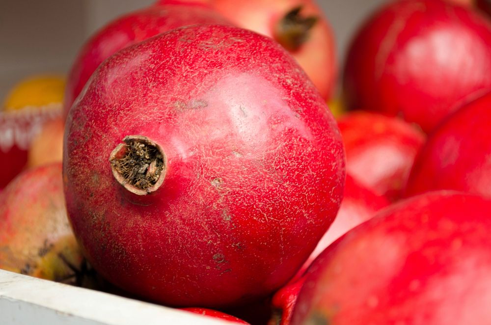 Closeup on pile of pomegranate fruit. Free public domain CC0 photo.