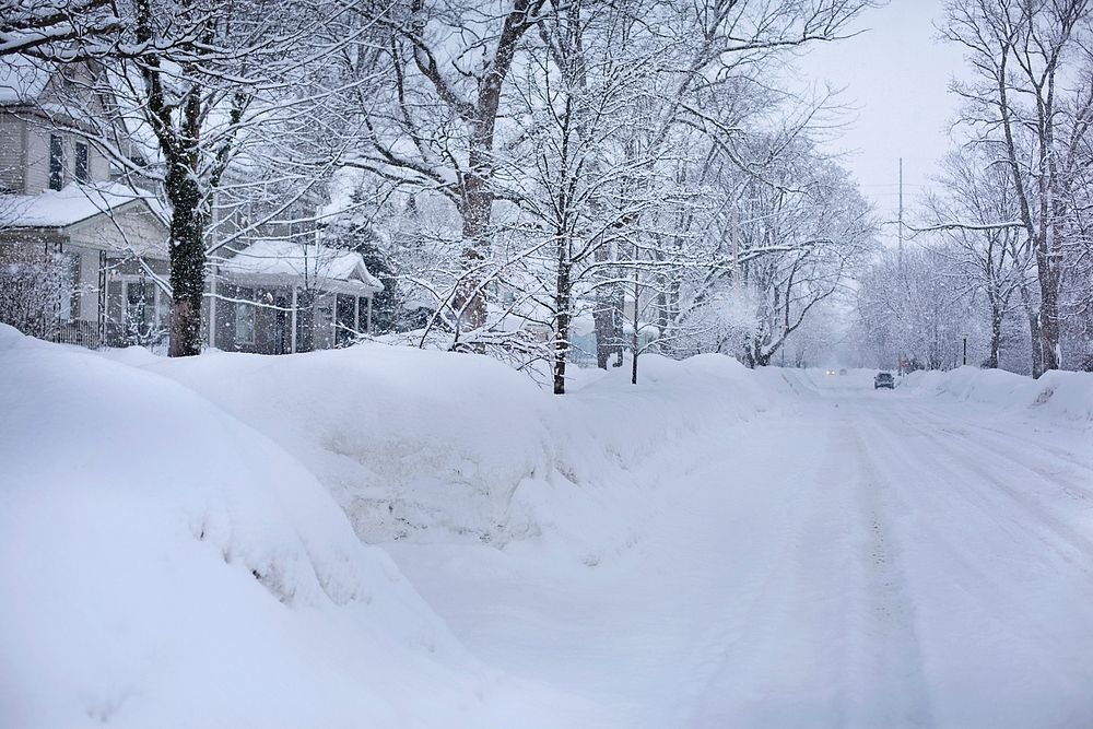 Empty neighborhood street covered in snow. Free public domain CC0 image.