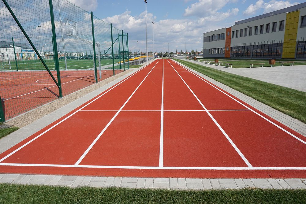 Empty running track and field during daytime. Free public domain CC0 photo.