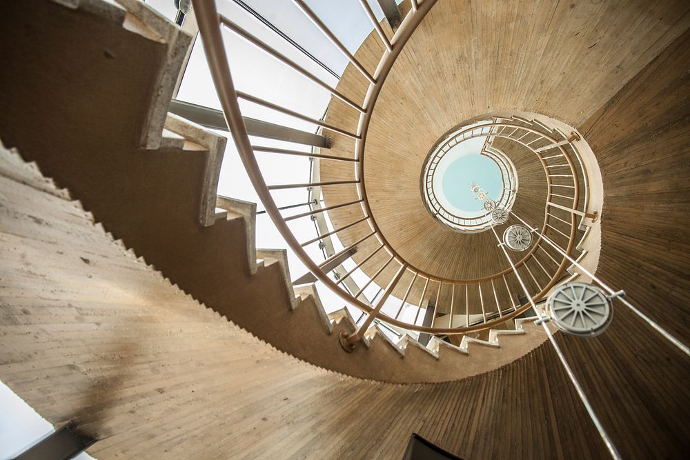 Looking up at a spiral staircase with metallic hand-rails. Free public domain CC0 photo.