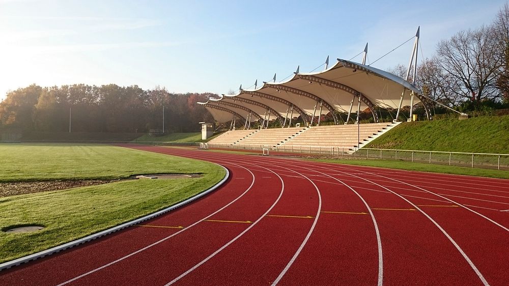 Empty running track and field during daytime. Free public domain CC0 photo.