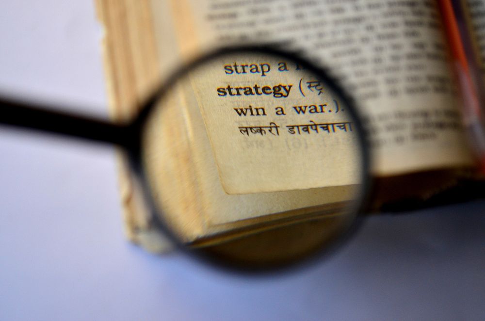 Magnifying glass on strategy text. Free public domain CC0 photo.