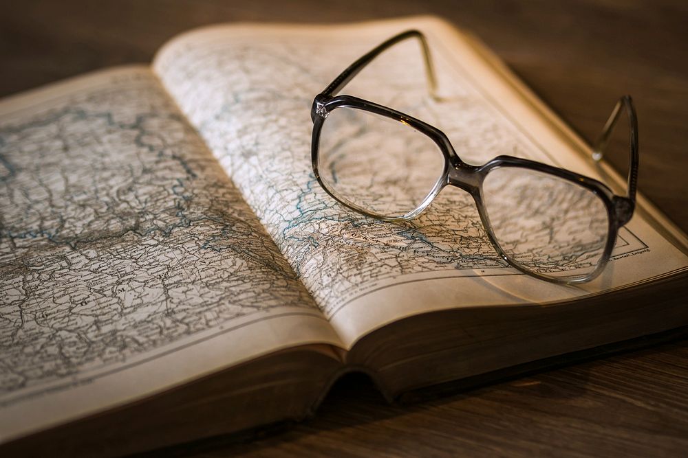 Free glasses on open map book photo, public domain CC0 image.