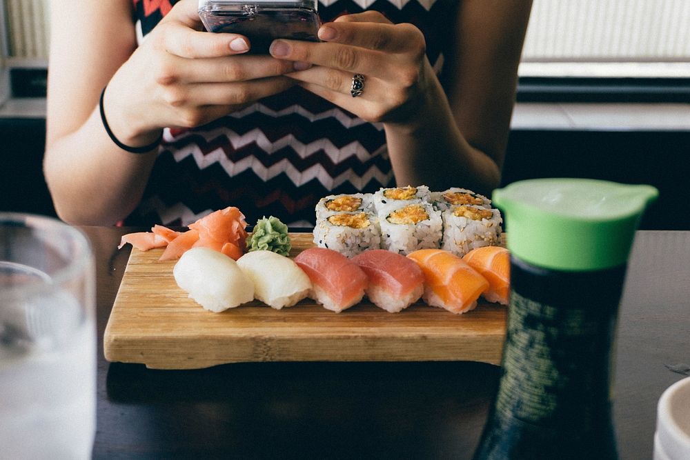 Free woman taking picture of sushi image, public domain food CC0 photo.