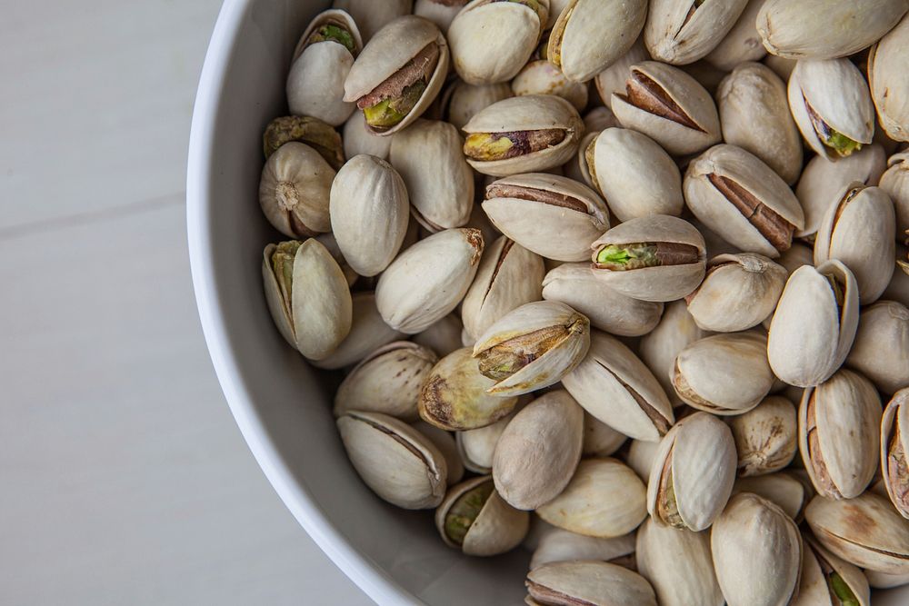Free shelled pistachio nuts in bowl photo, public domain food CC0 image.