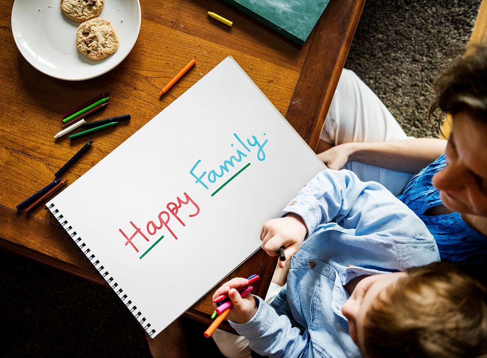 Kid writing Happy Family on a paper