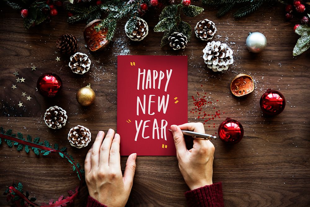 Woman writing Happy New Year on a card