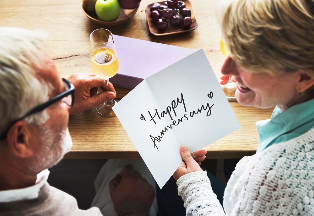 Mature couple holding an anniversary card