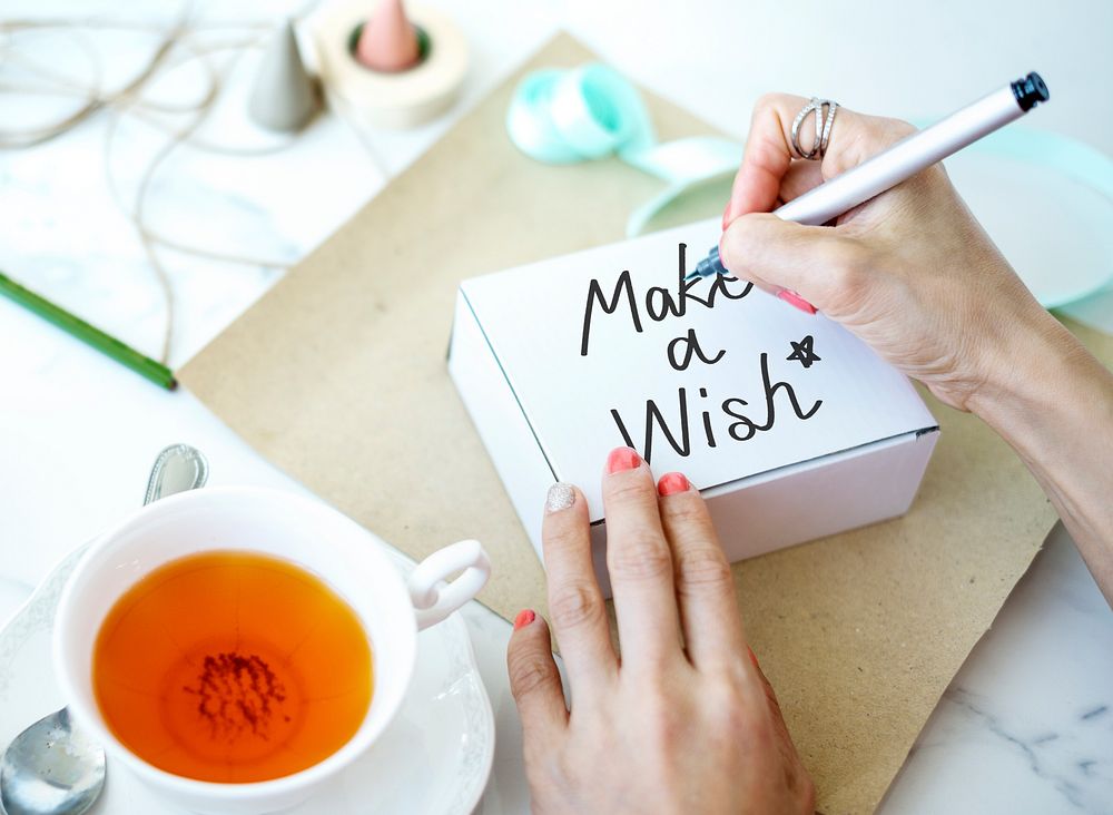 Woman writing Make a Wish on white box