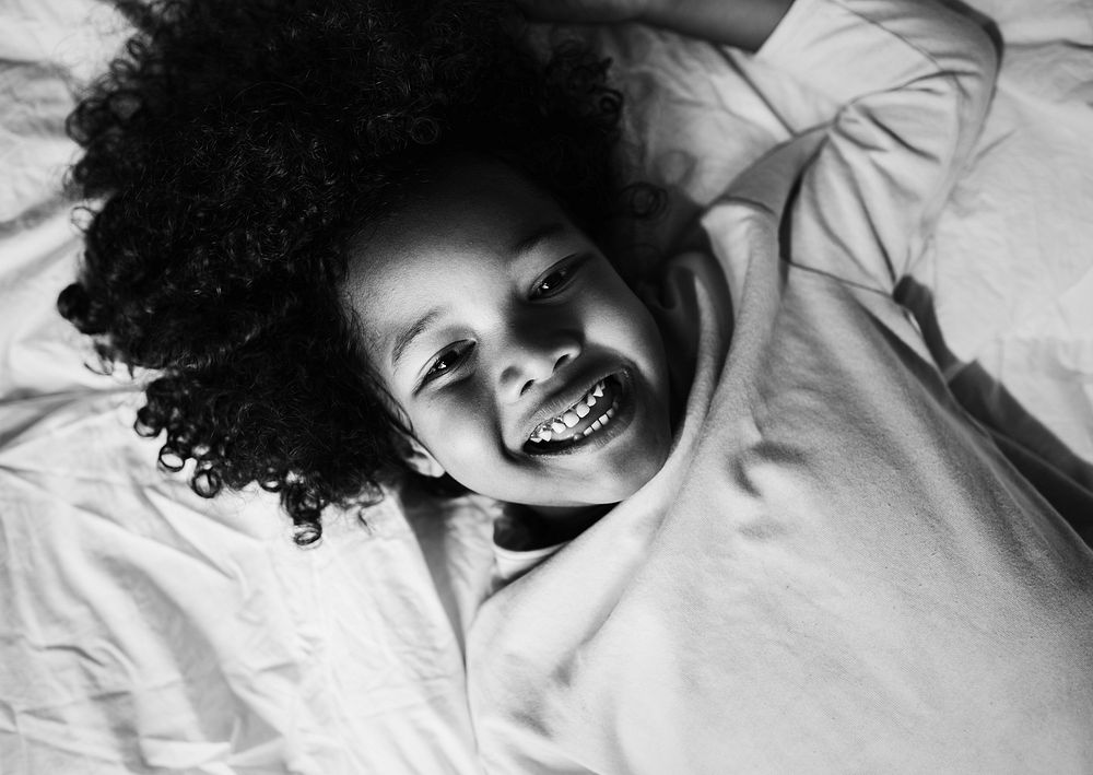 African child enjoying smiling on the bed