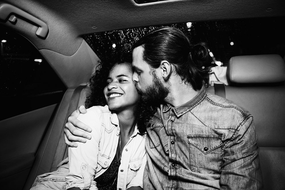 Romantic couple in the backseat of a taxi
