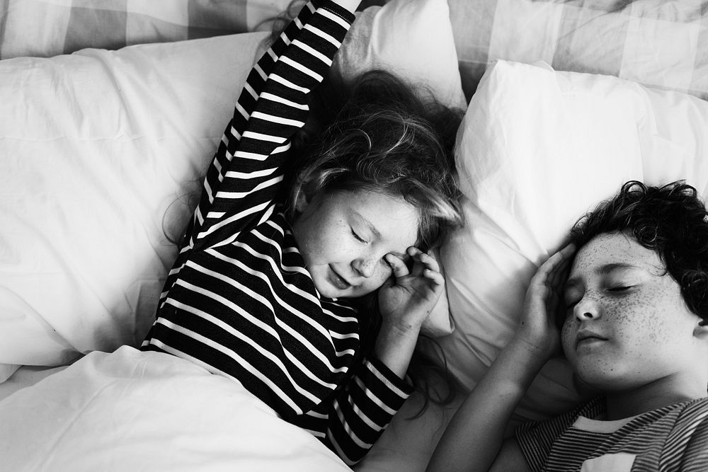 Caucasian siblings sleeping in the bed