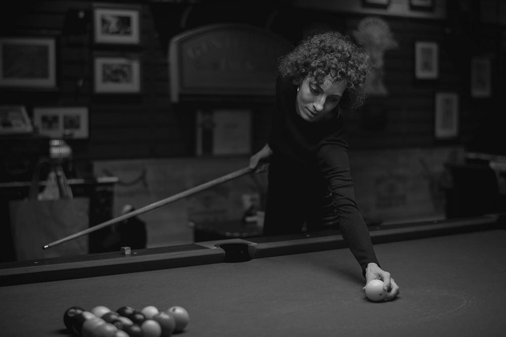 Single woman playing pool at a bar