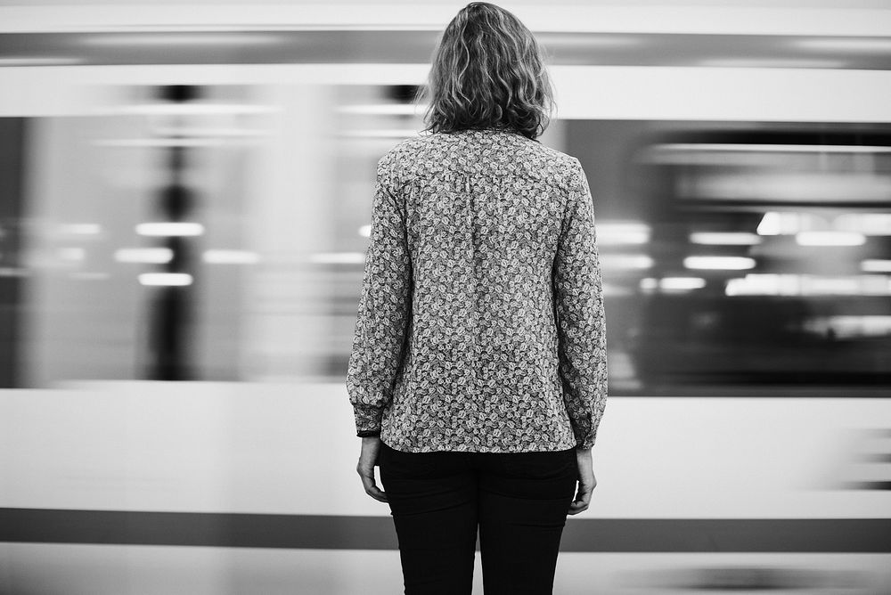 Rear view of a blond woman waiting at the train platform