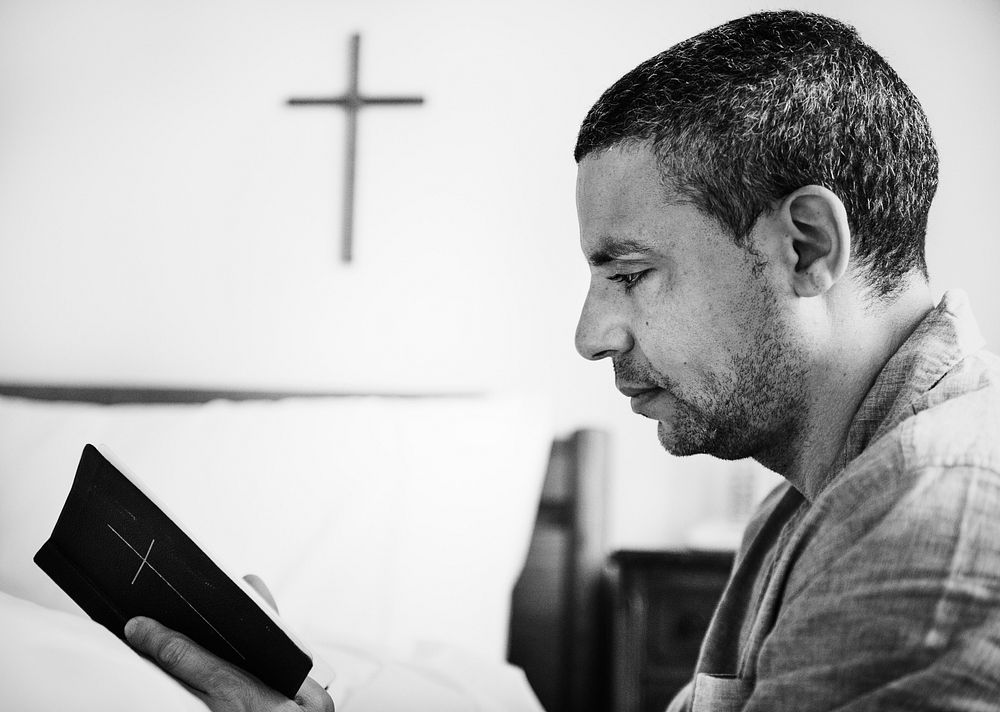 A man reading a bible alone