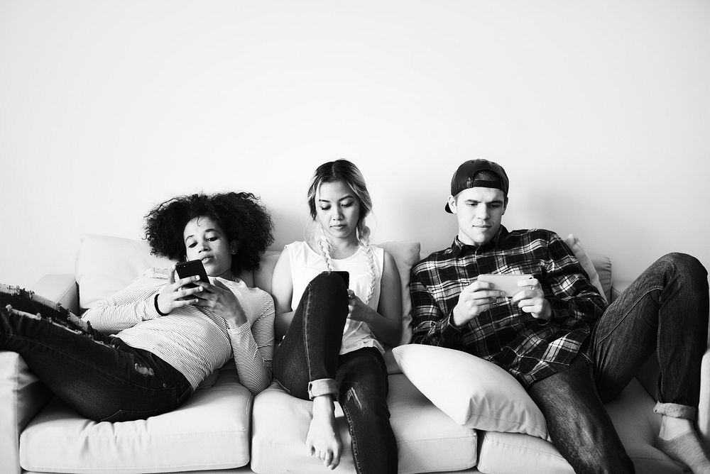 Friends using mobile phones on the couch