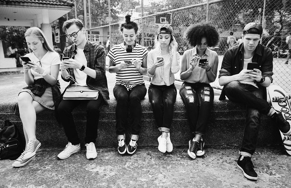 Young adult friends using smartphones
