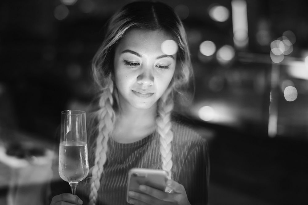Woman using a smartphone at a rooftop bar