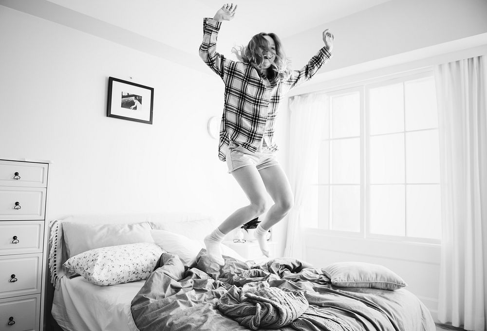 Caucasian girl jumping on the bed