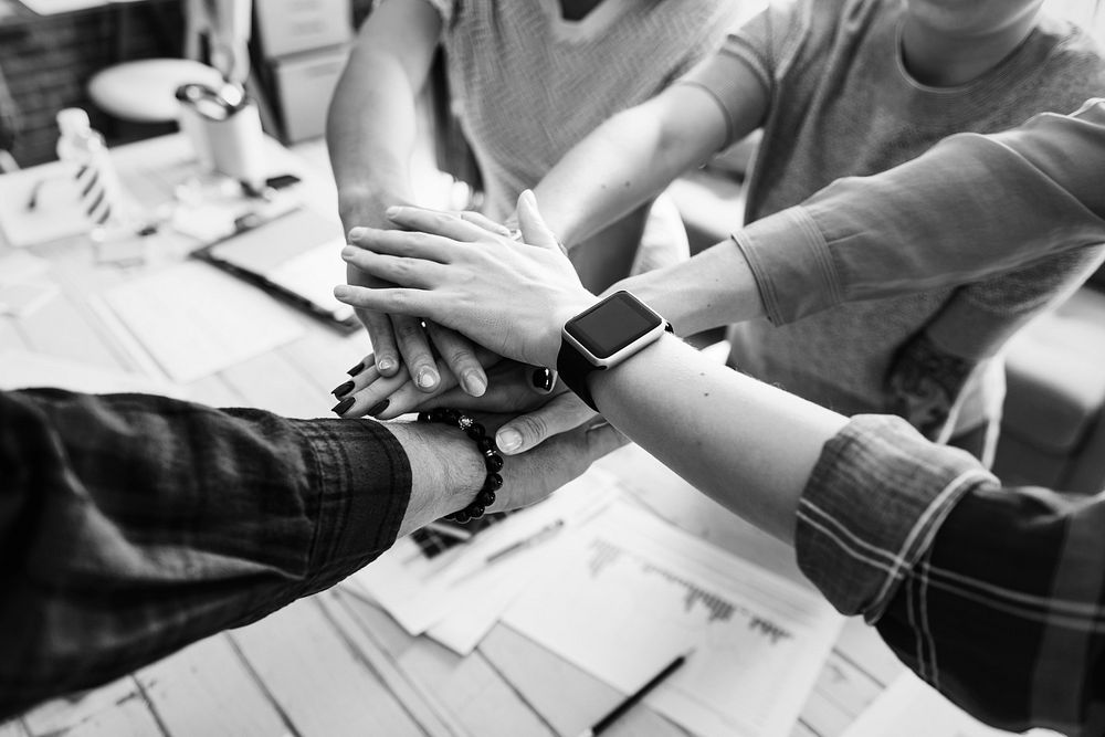 Co-workers stacking hands over a table