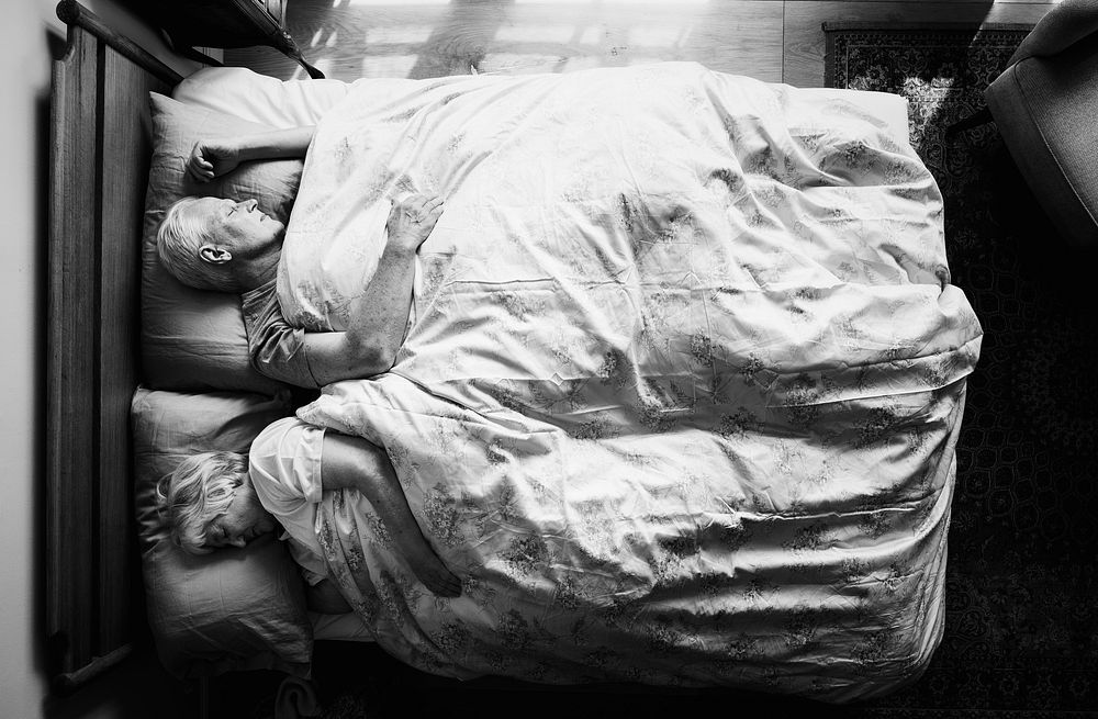 Elderly Caucasian couple sleeping in a bed