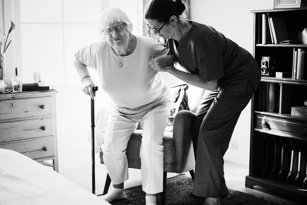 Nurse helping senior woman to stand