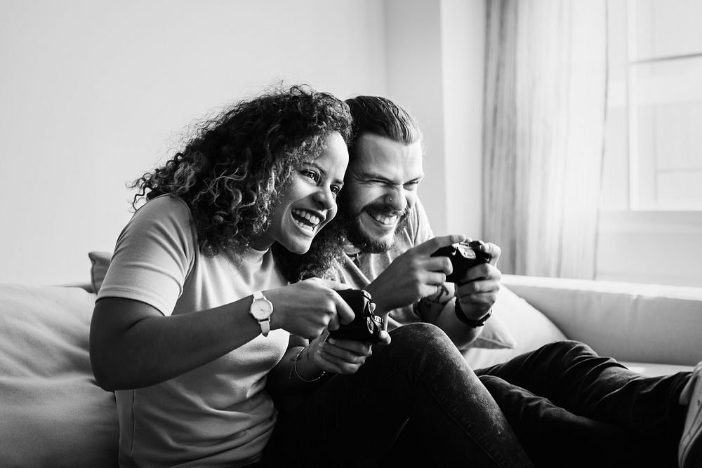 Couple playing video games at home