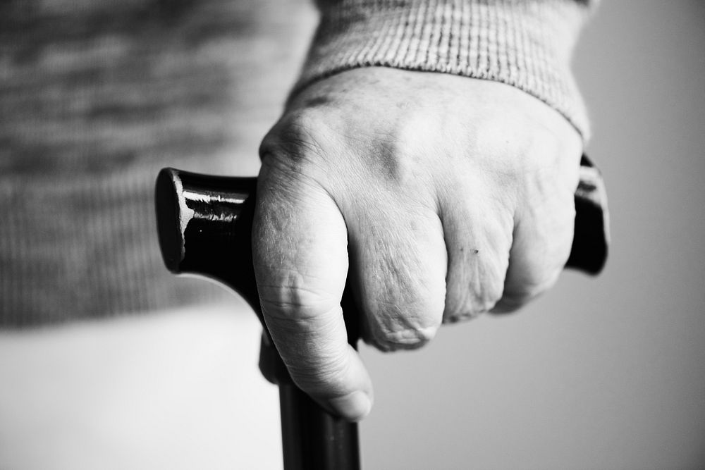 Closeup of elderly hand holding a walking stick
