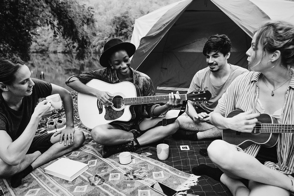 Young people playing guitar in the forest