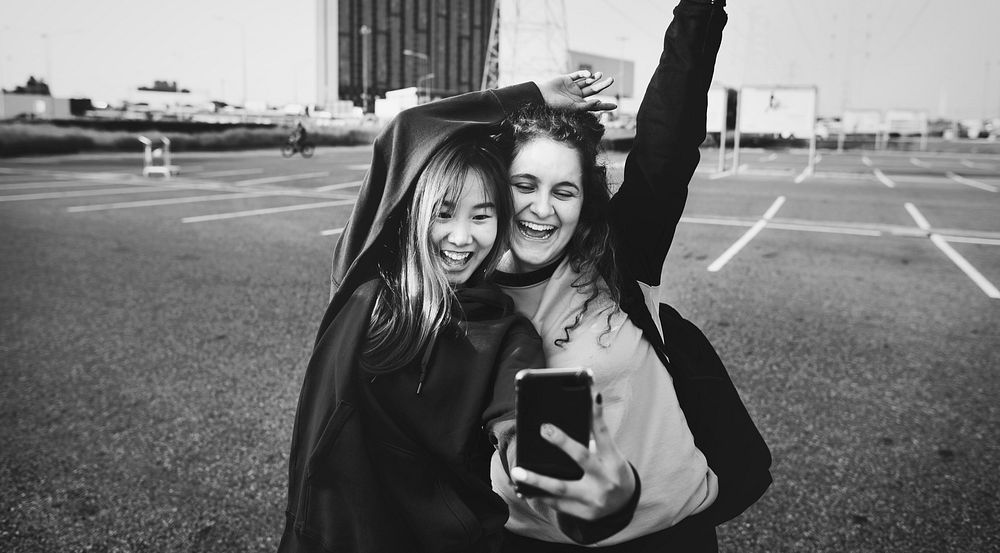 Girl friends smiling and taking a selfie