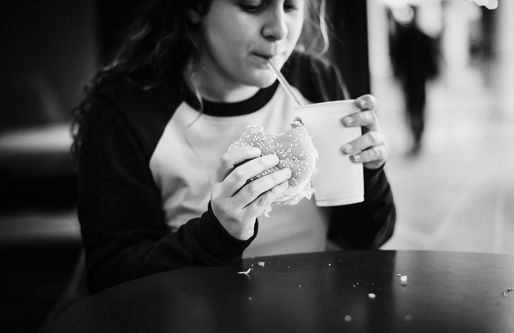Close up of teenage girl eating hamburger