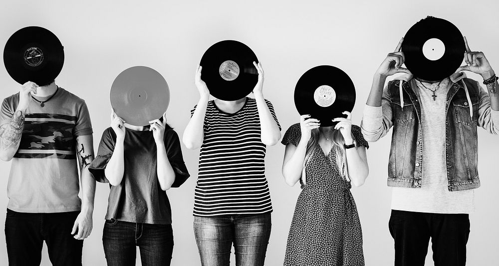 Young friends covering their faces with vinyls