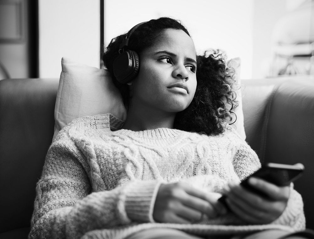 Woman listening to music on sofa