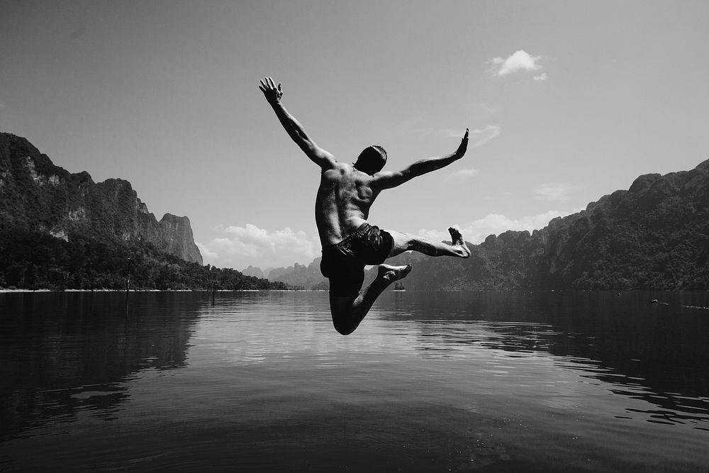 Man jumping with joy by a lake