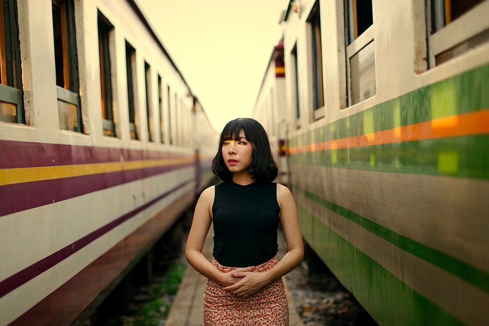 Asian woman between two trains