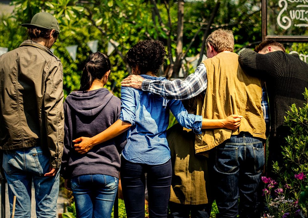 Group of people holding around each others backs