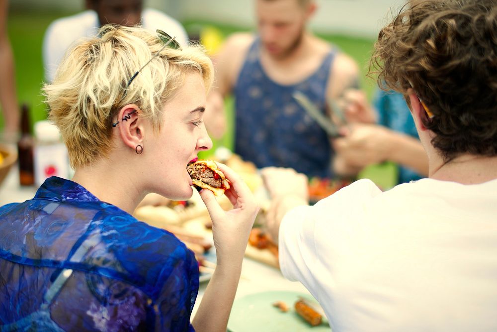 Girl eating a hamburger at a party