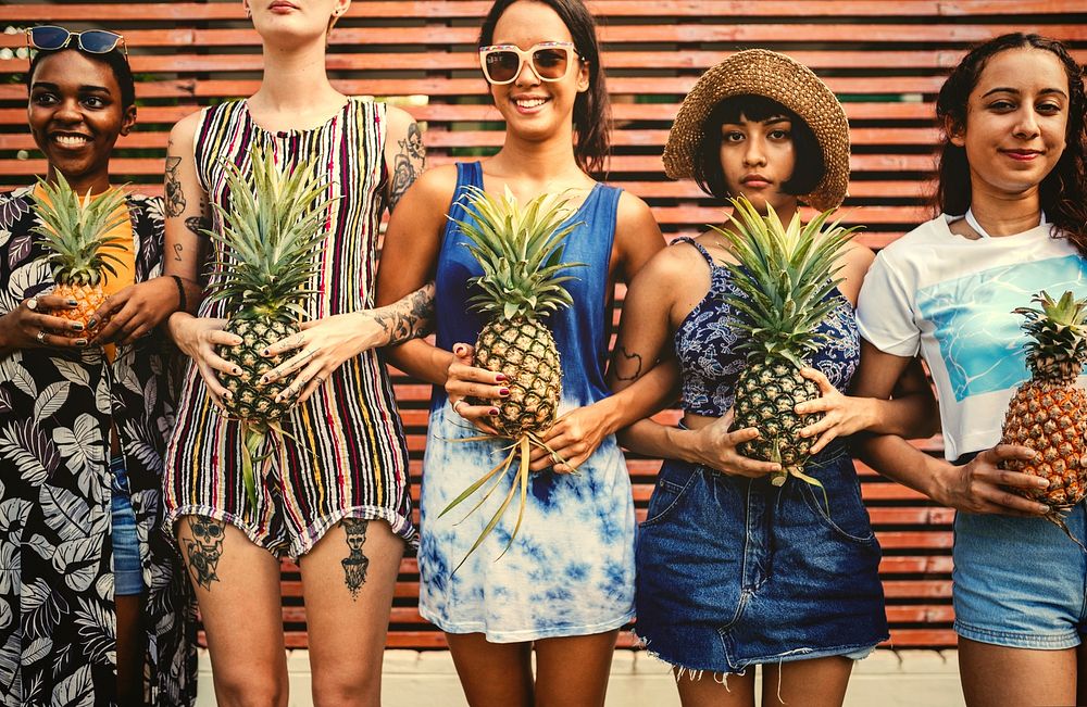 Pretty cool girls holding pineapples