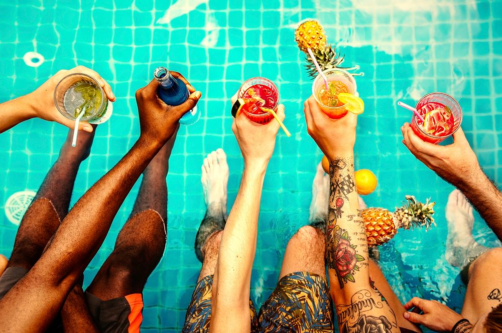 Friends drinking colorful drinks at a pool party