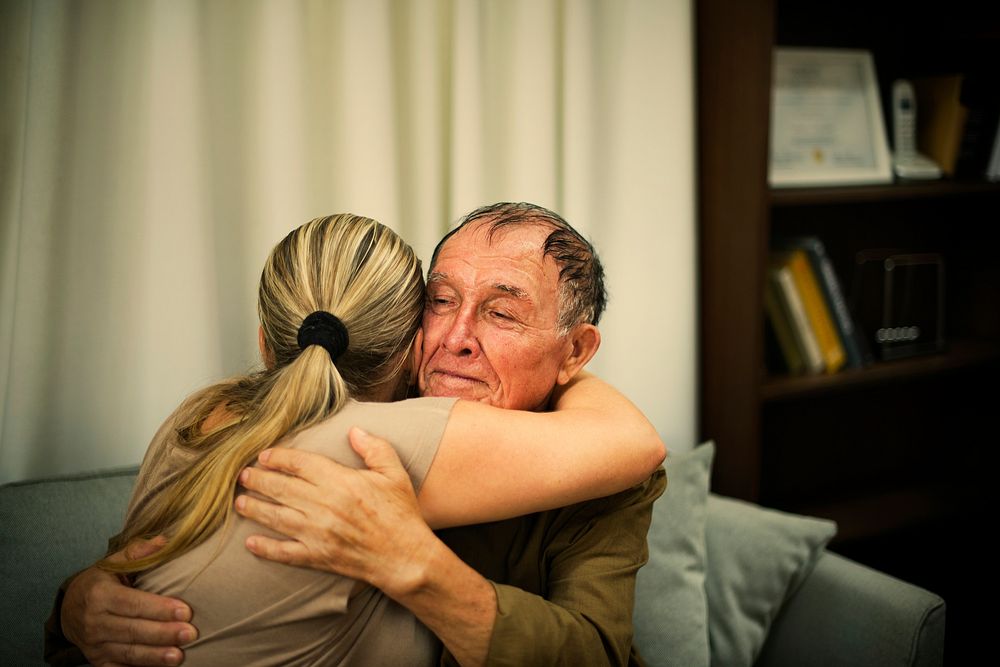 Daughter hugging her elderly father