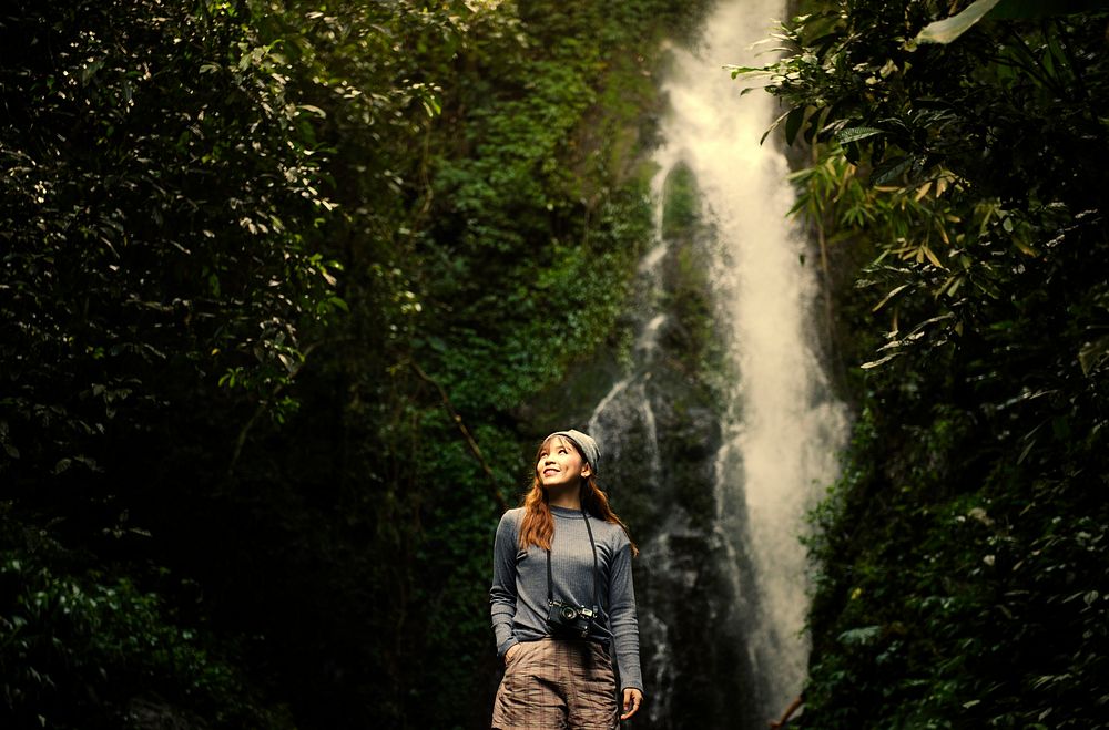 Asian woman enjoying a waterfall
