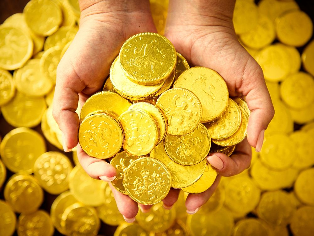 Hand full of shiny gold coins