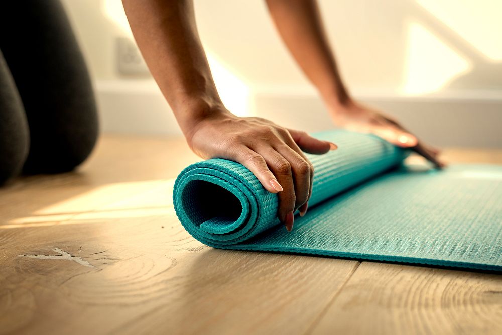 Woman rolling up a yoga mat