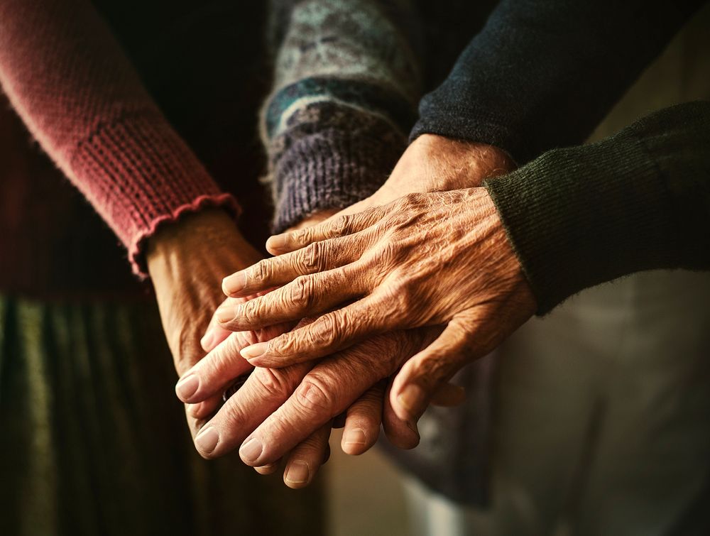 Elderly group of friends stacking hands