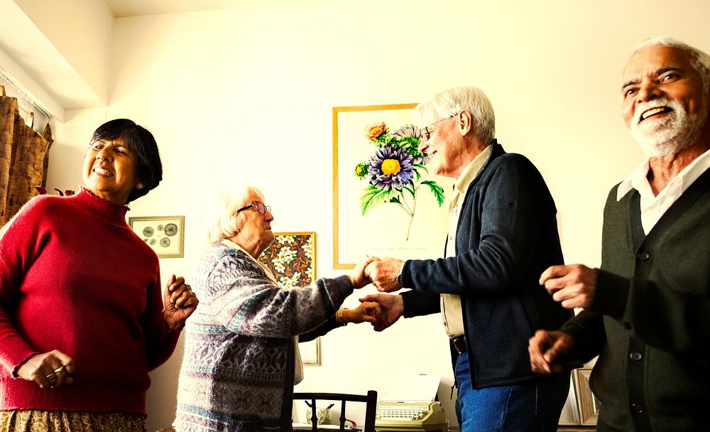 Senior friends dancing together in the home