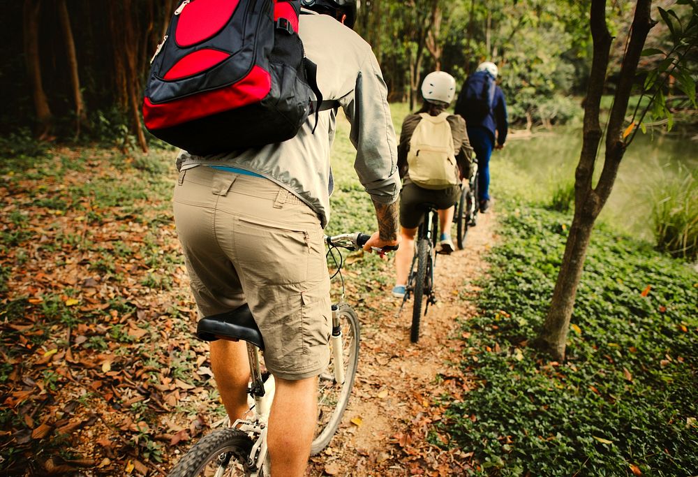Active friends riding bicycles through the forest