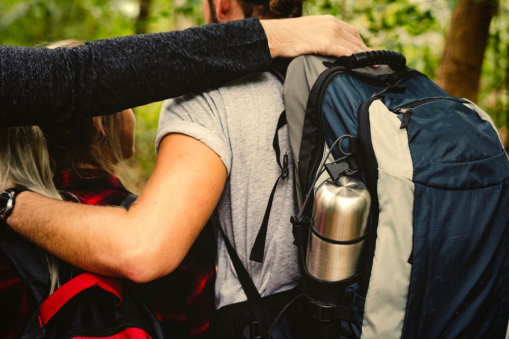 Friends with backpacks trekking through a forest